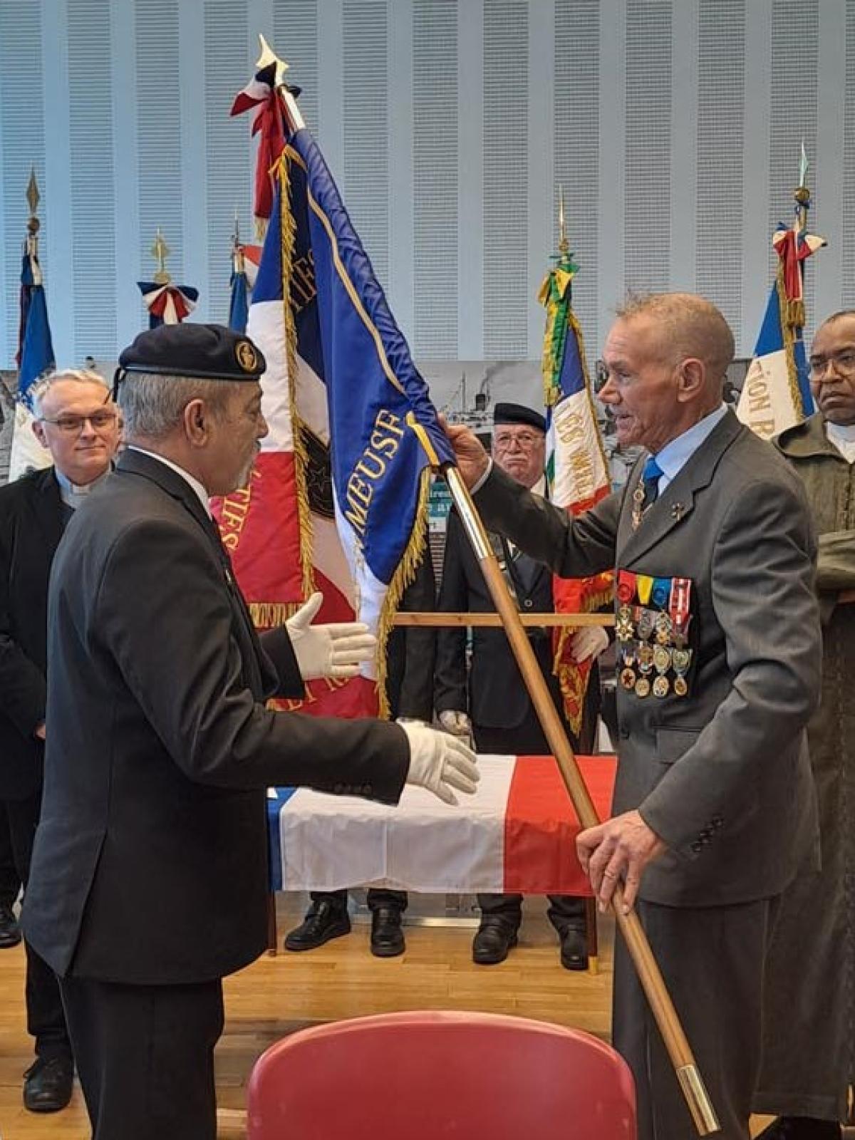 Le nouveau drapeau est remis au porte-drapeau par le président de l'AHSRM