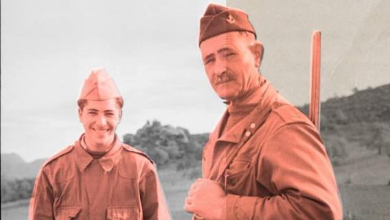 2 Harkis en tenue regardent l'objectif. Le plus âgé porte un fusil de chasse sur l'épaule. ALG 57-114 R28 @ Auteur inconnu / ECPAD / Défense